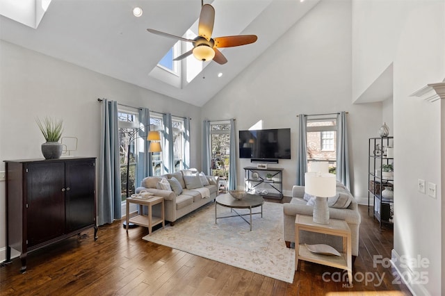 living room featuring a skylight, ceiling fan, and plenty of natural light