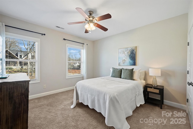 bedroom featuring ceiling fan, light colored carpet, and multiple windows