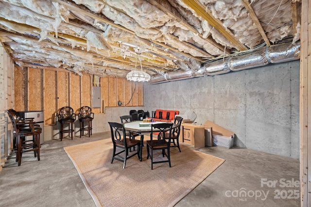 dining space featuring concrete flooring and electric panel