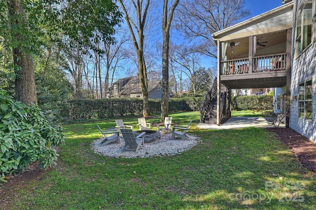 view of yard with a fire pit, ceiling fan, and a patio