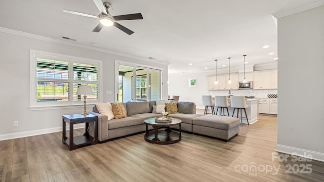 living room with ceiling fan, light hardwood / wood-style flooring, and ornamental molding