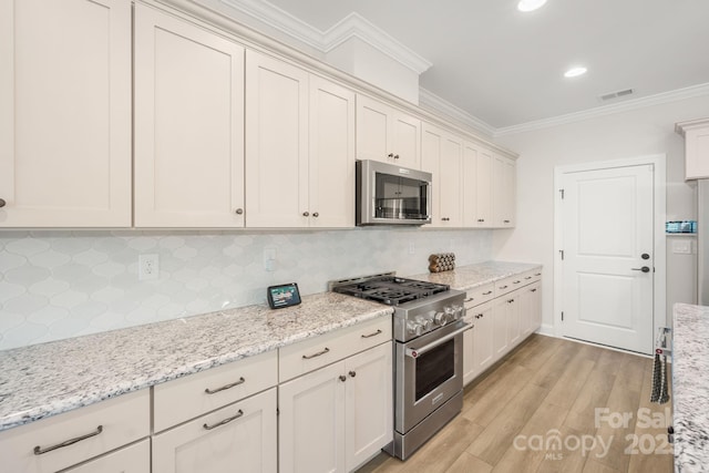 kitchen with backsplash, crown molding, light stone countertops, and stainless steel appliances