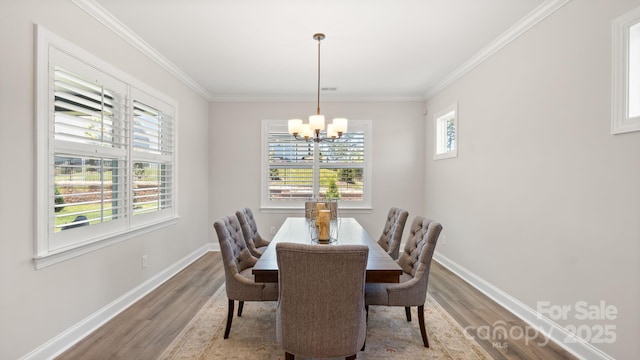 dining area with hardwood / wood-style flooring, a chandelier, and ornamental molding