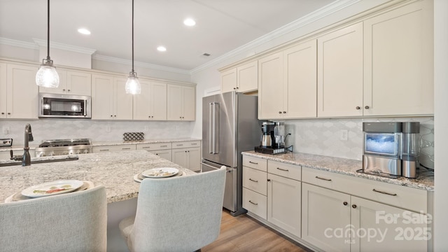 kitchen featuring light wood-type flooring, tasteful backsplash, light stone counters, stainless steel appliances, and decorative light fixtures