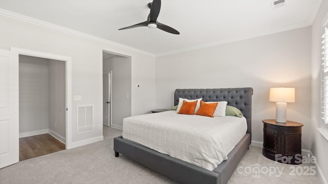 carpeted bedroom with ceiling fan and ornamental molding