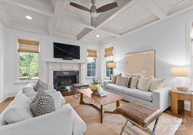 living room featuring beamed ceiling, a fireplace, wood-type flooring, and coffered ceiling