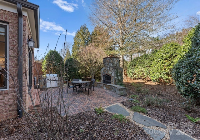 view of patio with an outdoor stone fireplace