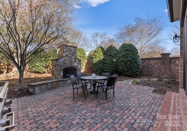 view of patio featuring an outdoor stone fireplace