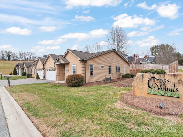 view of front of property featuring a front yard, a garage, and central air condition unit