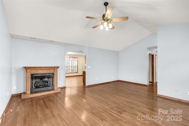 unfurnished living room with hardwood / wood-style flooring, ceiling fan, and vaulted ceiling