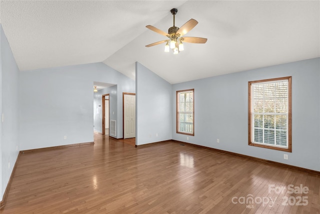 spare room with ceiling fan, plenty of natural light, wood-type flooring, and lofted ceiling