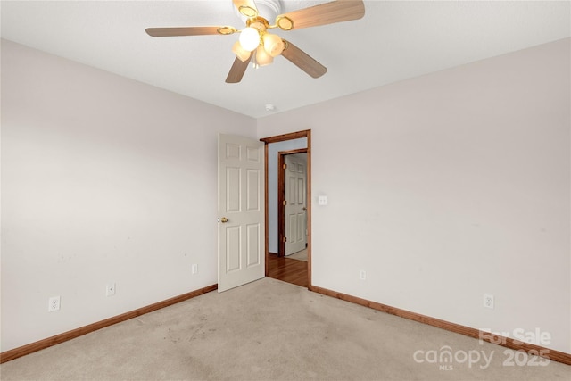 spare room with ceiling fan and light colored carpet