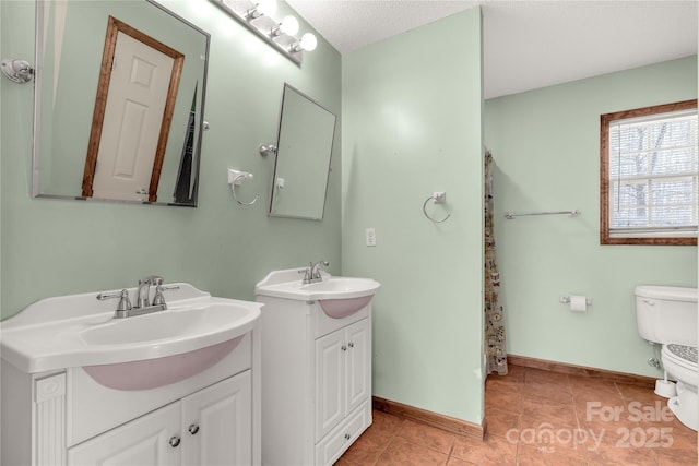 bathroom featuring tile patterned floors, vanity, toilet, and a textured ceiling