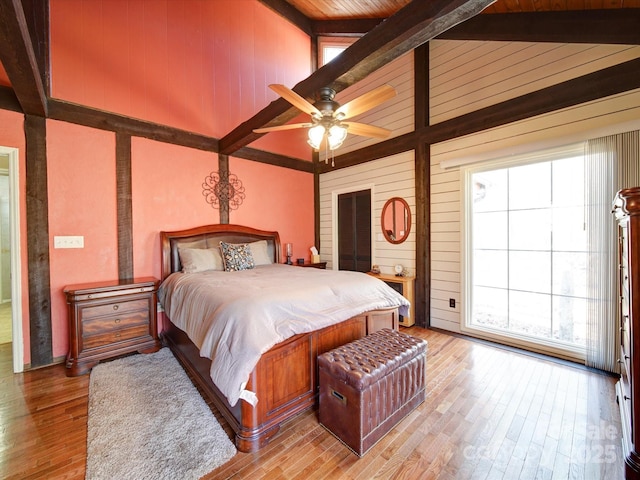 bedroom with lofted ceiling with beams, ceiling fan, wood ceiling, and hardwood / wood-style flooring