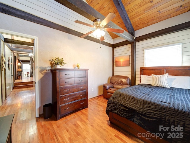 bedroom with light wood-type flooring, lofted ceiling with beams, ceiling fan, and wooden ceiling