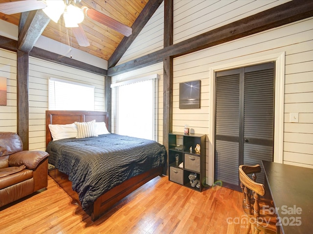 bedroom with ceiling fan, wooden ceiling, vaulted ceiling with beams, wooden walls, and light wood-type flooring