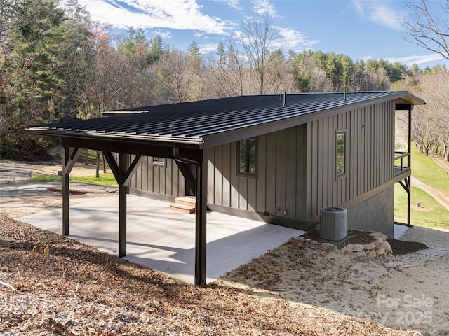 view of side of property featuring central air condition unit and a patio area