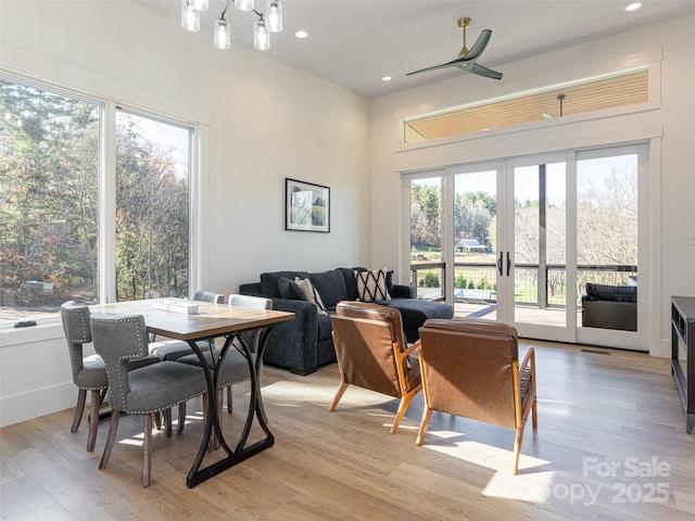 dining room with ceiling fan, a healthy amount of sunlight, light wood-type flooring, and french doors