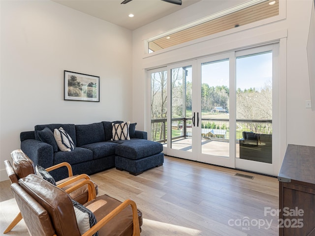 living room with ceiling fan and light hardwood / wood-style floors