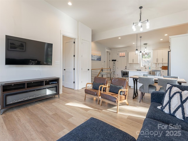 living room with light hardwood / wood-style flooring and a notable chandelier