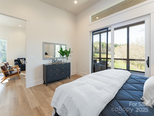 bedroom featuring access to exterior, multiple windows, and light hardwood / wood-style flooring