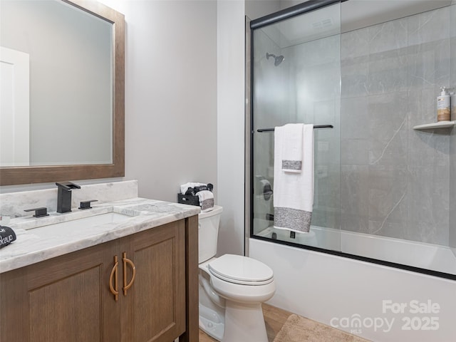 full bathroom with shower / bath combination with glass door, vanity, and toilet