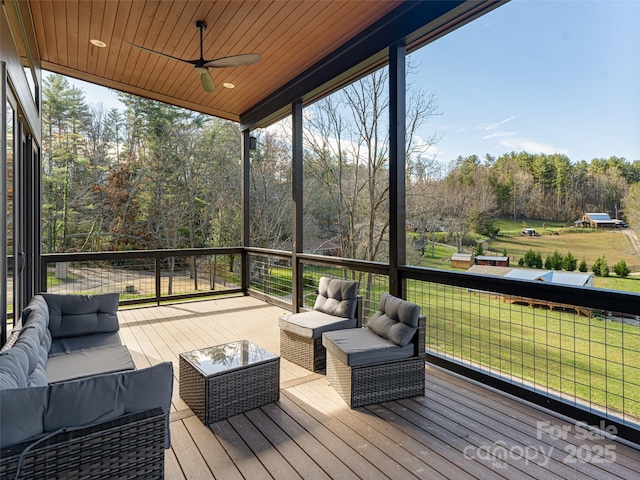 sunroom with a healthy amount of sunlight, ceiling fan, and wooden ceiling