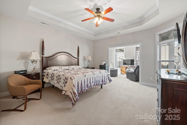 carpeted bedroom with a raised ceiling, multiple windows, and ceiling fan