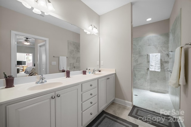 bathroom featuring tiled shower, vanity, tile patterned floors, and ceiling fan