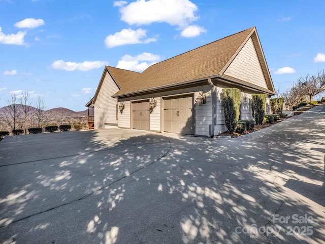 view of side of property featuring a garage and a mountain view