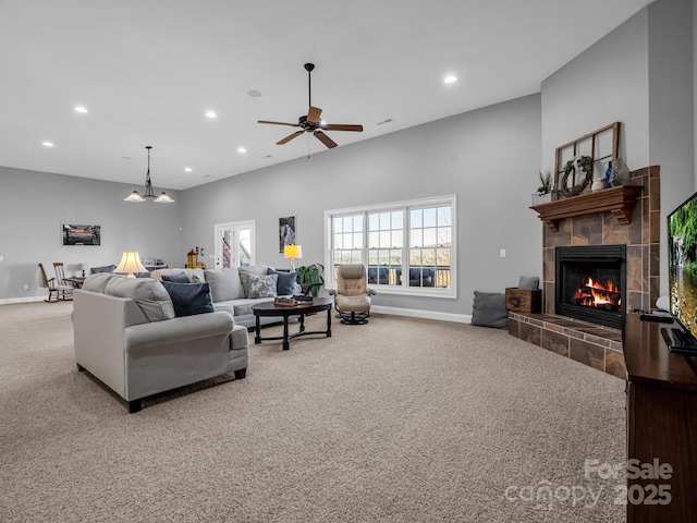 living room with a fireplace, ceiling fan, and carpet