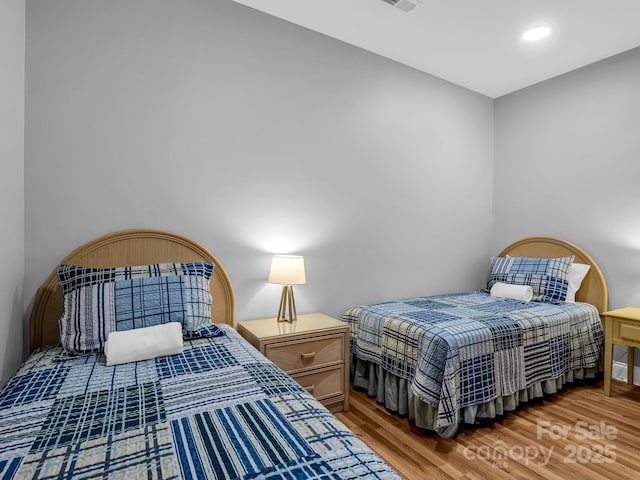 bedroom featuring light wood finished floors, visible vents, and recessed lighting