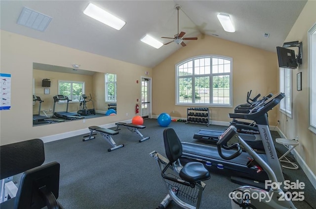 gym with lofted ceiling, visible vents, and baseboards