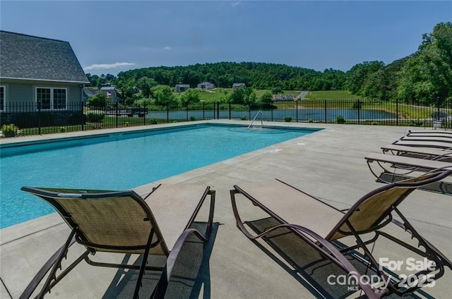 community pool with fence and a patio