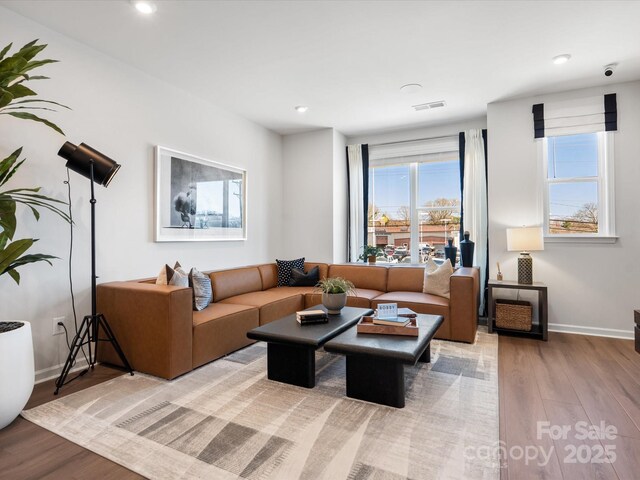 living area featuring recessed lighting, wood finished floors, visible vents, and baseboards