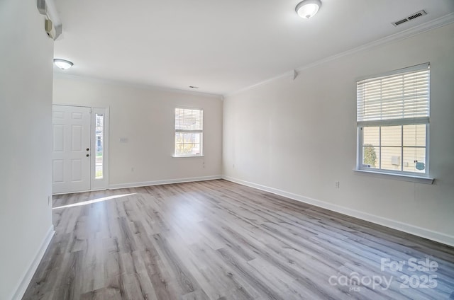 spare room featuring crown molding and light wood-type flooring