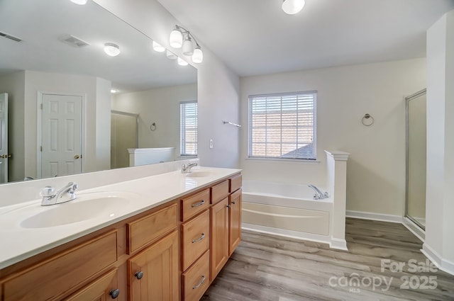 bathroom with vanity, wood-type flooring, and shower with separate bathtub