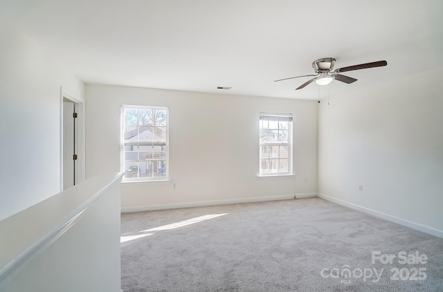 carpeted empty room with a wealth of natural light and ceiling fan