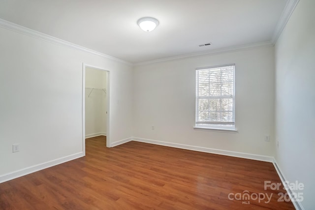 unfurnished room featuring wood-type flooring and ornamental molding