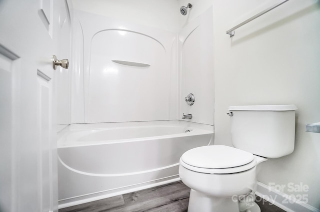 bathroom featuring bathtub / shower combination, hardwood / wood-style flooring, and toilet