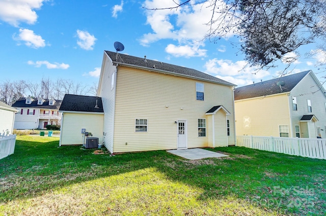 back of property with cooling unit, a patio area, and a lawn