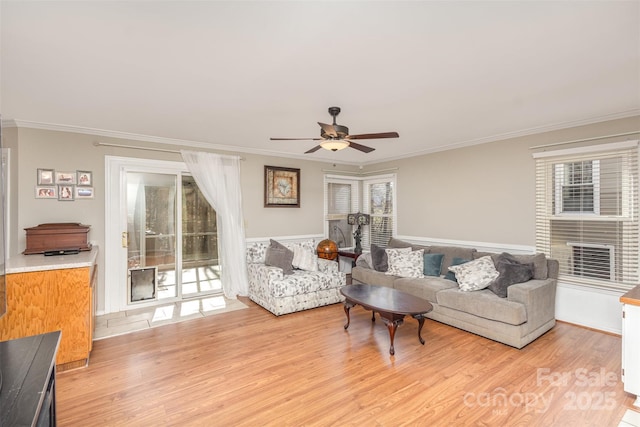 living room with ceiling fan, light hardwood / wood-style flooring, plenty of natural light, and ornamental molding