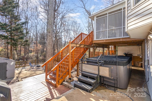 wooden terrace featuring a hot tub, a patio area, and a sunroom