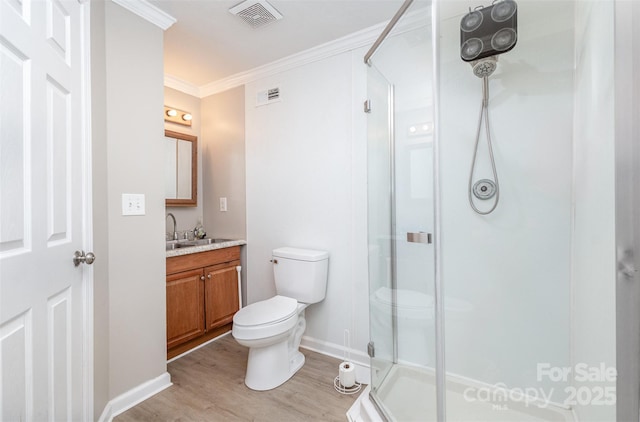 bathroom with crown molding, an enclosed shower, toilet, vanity, and hardwood / wood-style flooring