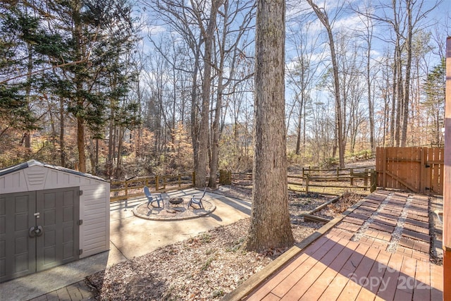 wooden deck featuring a fire pit and a storage shed