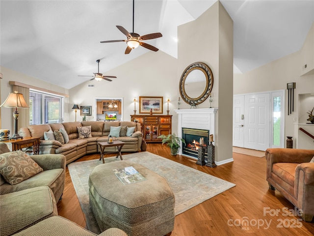 living room featuring hardwood / wood-style flooring, ceiling fan, and lofted ceiling