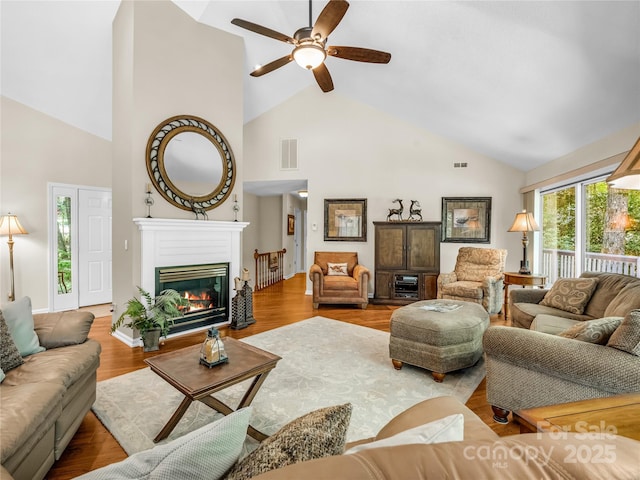 living room featuring light wood-type flooring, high vaulted ceiling, and ceiling fan