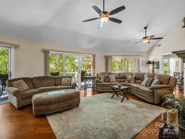 living room with wood-type flooring, ceiling fan, and lofted ceiling