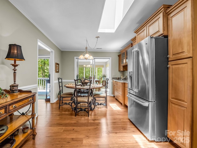 kitchen featuring a wealth of natural light, a skylight, high quality fridge, and ornamental molding