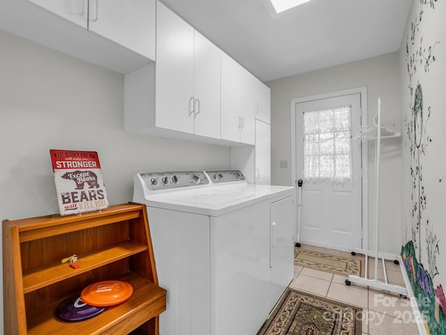 washroom with cabinets, washer and dryer, and light tile patterned flooring